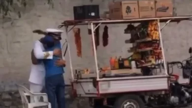 Padre vendedor ambulante ajusta el uniforme de Julián antes de su graduación de la Marina