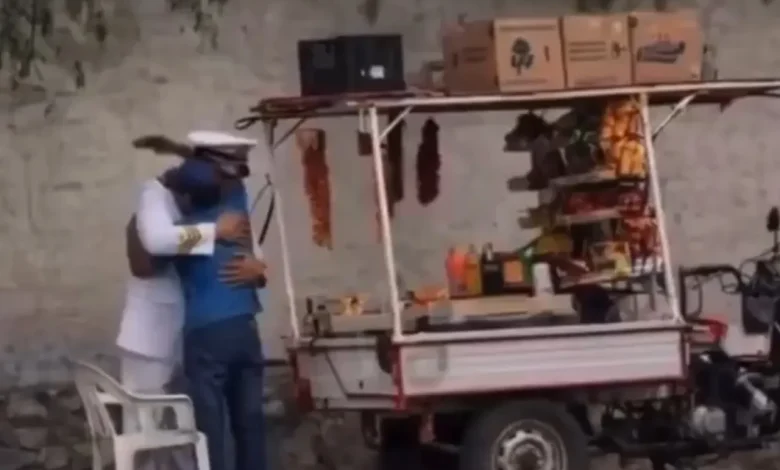 Padre vendedor ambulante ajusta el uniforme de Julián antes de su graduación de la Marina